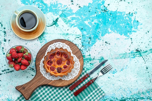 Vue de dessus du cupcake aux fraises à côté de cuillère et fourchette et americano