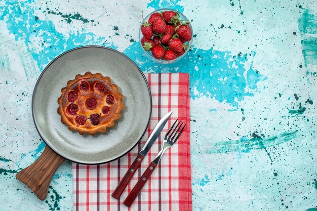 Vue de dessus du cupcake avec surface frite et fraises sur nappe