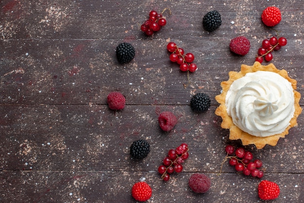 Vue de dessus du délicieux gâteau crémeux avec des baies différentes réparties sur tout le sol brun berry fruits crème cuire biscuit