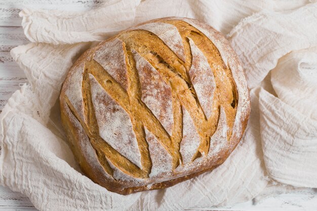 Vue de dessus du délicieux pain au four sur un tissu blanc