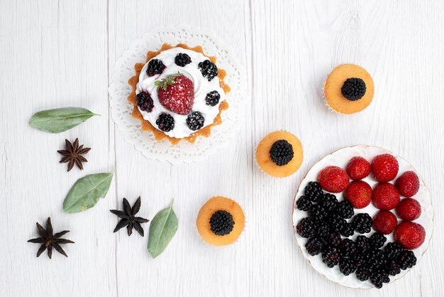 Vue de dessus du délicieux petit gâteau avec des biscuits à la crème et aux baies sur blanc, biscuit gâteau cuire au four fruits doux