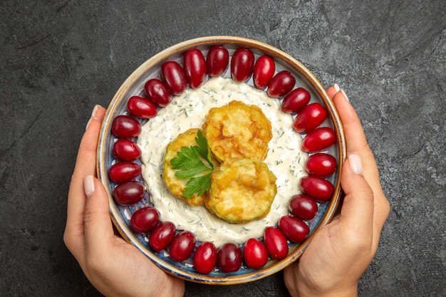 Vue de dessus du délicieux repas de courge avec cornouiller rouge frais sur une surface gris foncé