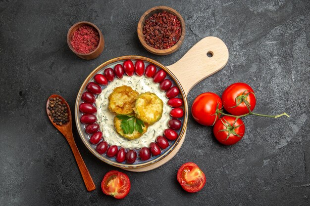 Vue de dessus du délicieux repas de courge avec des tomates et des assaisonnements de cornouiller rouge frais sur une surface grise