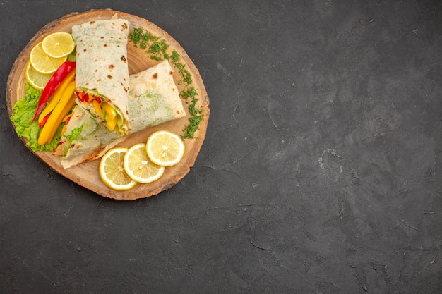 Vue de dessus du délicieux sandwich à la viande shaurma en tranches avec des tranches de citron sur fond noir