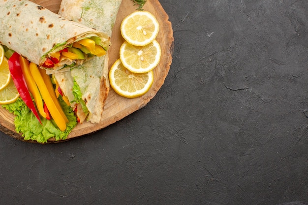 Vue de dessus du délicieux sandwich à la viande shaurma en tranches avec des tranches de citron sur un tableau noir