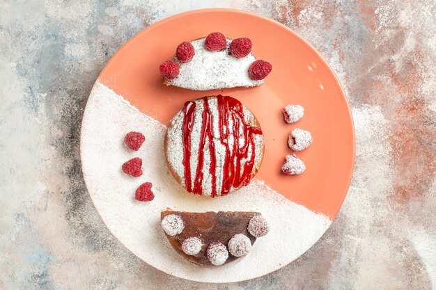 Vue de dessus du dessert sucré avec sauce dessus et baies sur le côté sur fond de marbre orange