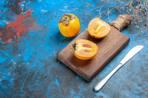 Photo gratuite vue de dessus du diospyros kaki entier et coupé avec un couteau