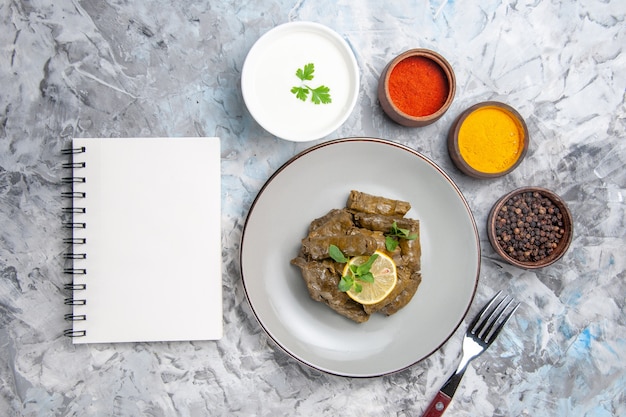 Vue de dessus du dolma feuille verte avec assaisonnements sur surface blanche