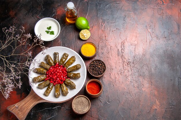 Vue de dessus du dolma feuille verte avec assaisonnements sur la surface sombre