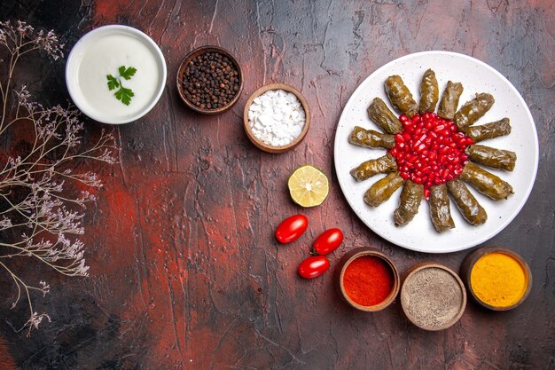 Vue de dessus du dolma feuille verte avec assaisonnements sur la surface sombre