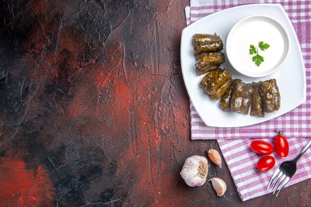 Vue de dessus du dolma feuille verte avec du yaourt sur la surface sombre