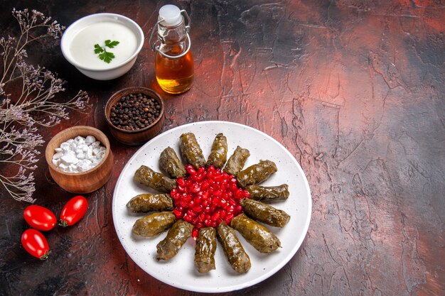 Vue de dessus du dolma feuille verte avec des grenades sur une surface sombre