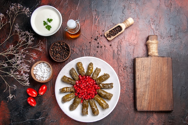 Vue de dessus du dolma feuille verte avec des grenades sur une surface sombre