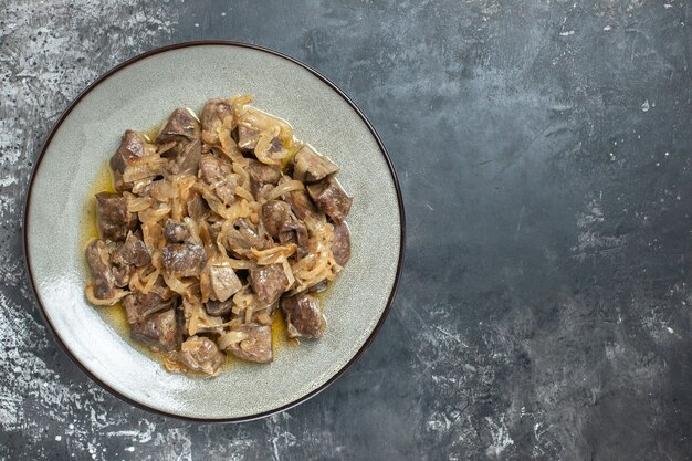 Vue de dessus du foie et de l'oignon cuits sur une assiette ovale