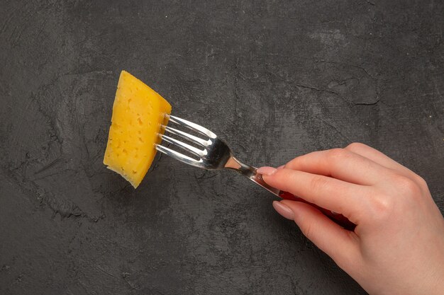 Vue de dessus du fromage frais en tranches sur fond sombre de la fourche