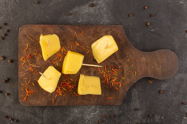 Une vue de dessus du fromage jaune frais avec des graines de café brun sur le bureau gris café collation repas alimentaire