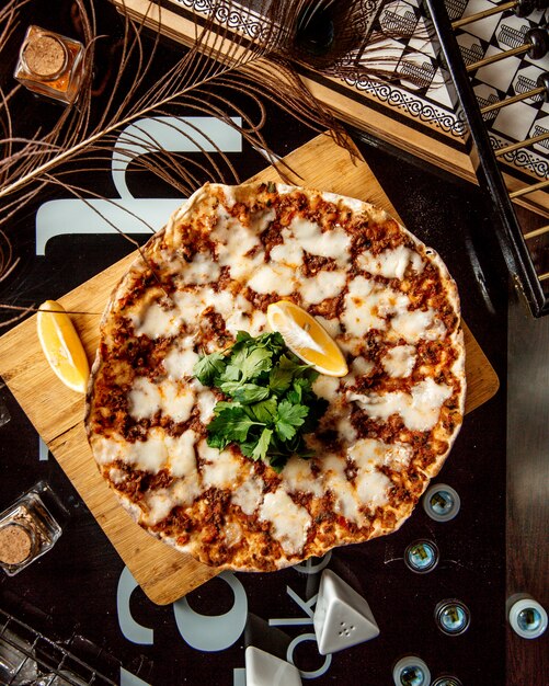 Vue de dessus du fromage à pizza turque lahmajun servi avec du persil et du citron