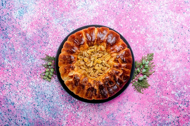 Vue de dessus du gâteau aux raisins secs gâteau à la tarte au four rond formé sur le bureau rose