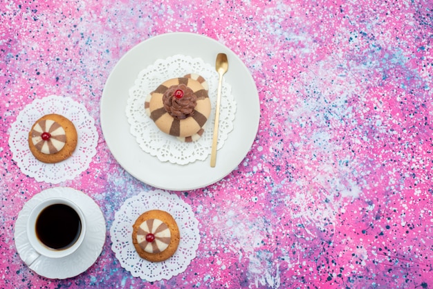 Vue de dessus du gâteau et des biscuits avec une tasse de café sur le fond coloré de sucre de couleur gâteau cookie