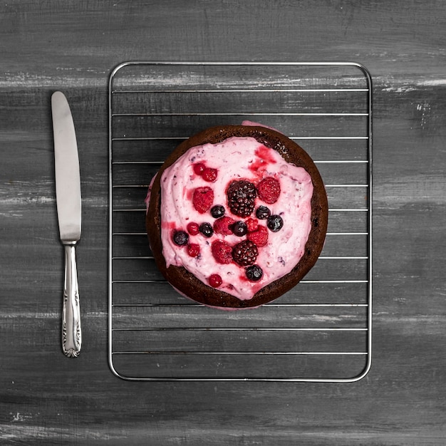 Vue de dessus du gâteau sur la grille de refroidissement avec couteau