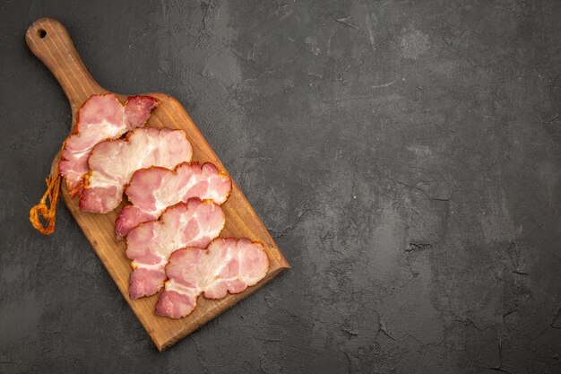 Vue de dessus du jambon tranché sur un bureau en bois et le fond gris