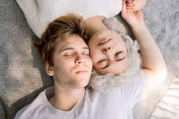 Vue de dessus du joli couple à l'extérieur sur une couverture se détendre ensemble