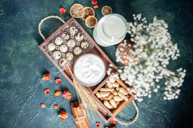 Vue de dessus du lait frais avec des œufs et des noix sur fond bleu foncé cuire au four gâteau biscuit pâte à tarte pain pâtisserie sucre