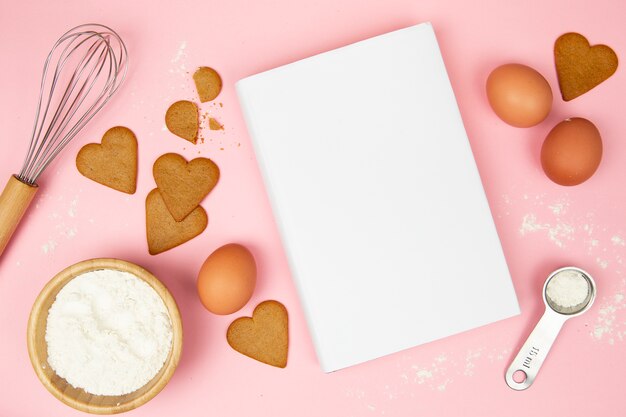 Vue de dessus du livre et des cookies sur fond rose