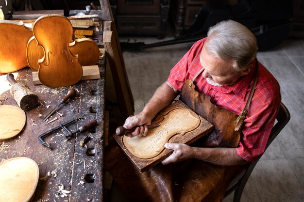 Vue de dessus du menuisier senior travaillant dans son atelier à l'ancienne