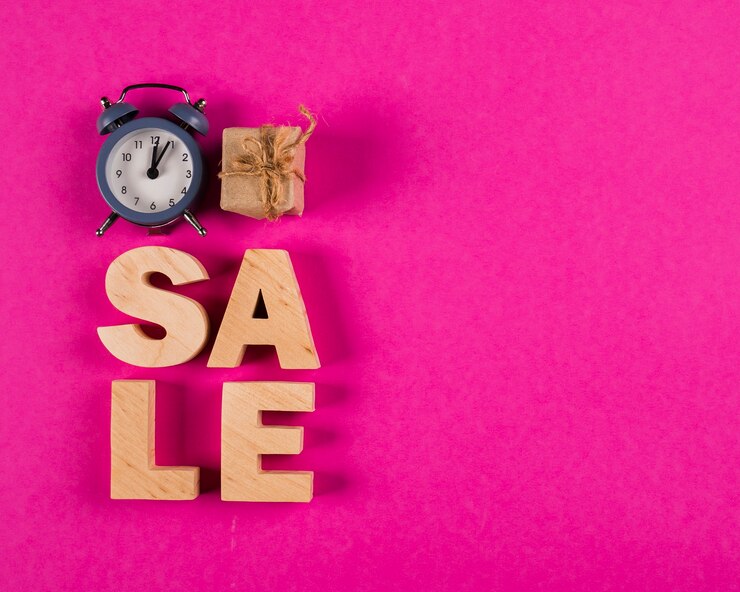 Photo gratuit vue de dessus du mot vente et horloge sur fond rose