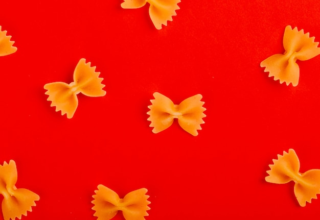 Vue de dessus du motif de pâtes farfalle sur surface rouge