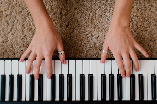 Photo gratuite vue de dessus du musicien féminin jouant du clavier de piano