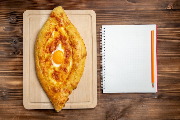 Vue de dessus du pain cuit avec des oeufs cuits sur la surface en bois de la pâte à pain pain petit-déjeuner alimentaire