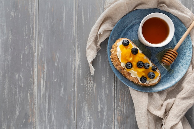 Vue De Dessus Du Pain Avec Du Fromage à La Crème Et Des Fruits Sur Une Assiette Avec Copie-espace