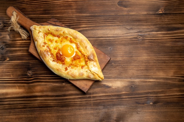 Vue de dessus du pain frais avec des œufs cuits sur la surface en bois de la pâte à pain pain petit-déjeuner alimentaire