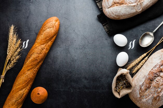 Vue de dessus du pain et des ingrédients sur fond noir