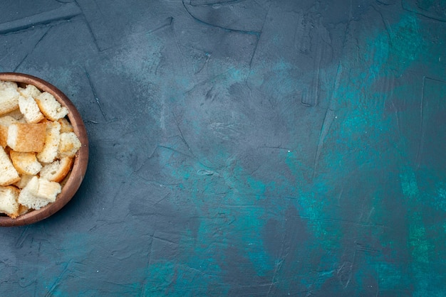 Photo gratuite vue de dessus du pain tranché à l'intérieur d'un bol brun sur le fond bleu foncé pain biscotte couleur photo