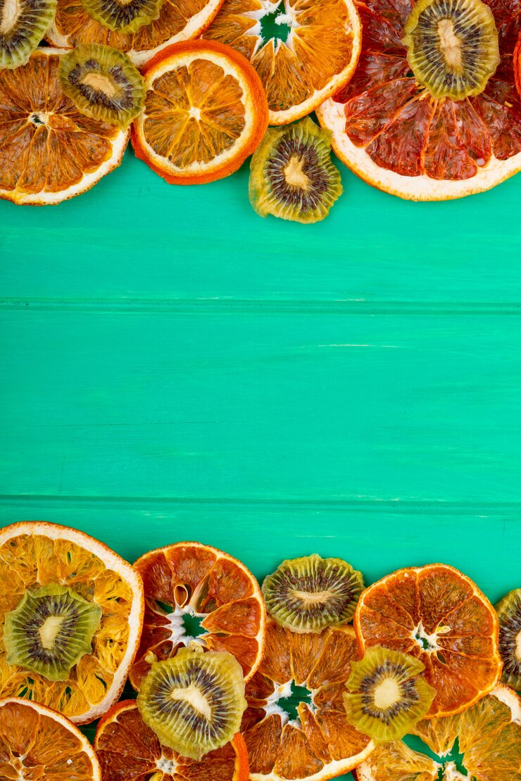 Photo gratuit vue de dessus du pamplemousse séché et des tranches d'orange avec du kiwi séché sur fond de bois vert avec copie espace