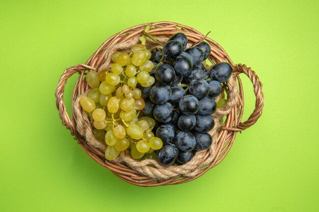 Vue de dessus du panier en bois de raisins de raisins verts et noirs