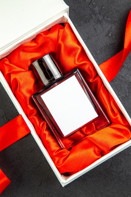Photo gratuite vue de dessus du parfum cher dans un emballage élégant en cadeau sur une table sombre