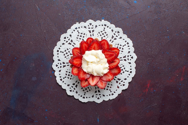 Photo gratuite vue de dessus du petit gâteau crémeux avec des fruits en tranches sur la surface sombre