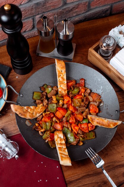 Vue de dessus du plat traditionnel azerbaïdjanais saj kebab avec des morceaux de champignons de viande et de légumes sur la table