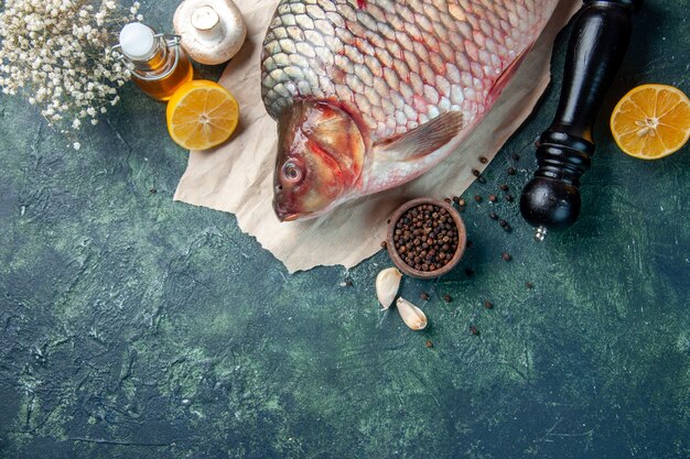 Vue de dessus du poisson cru frais aux champignons sur fond bleu foncé