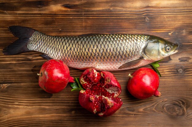 Vue de dessus du poisson frais aux grenades sur un bureau en bois