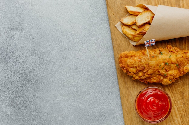 Vue de dessus du poisson-frites dans du papier d'emballage avec du ketchup et de l'espace de copie