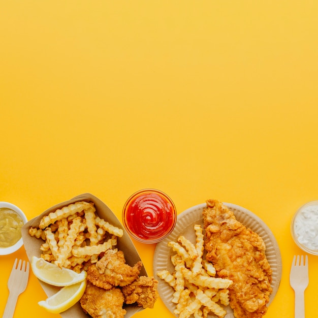 Vue de dessus du poisson-frites avec une variété de sauces et espace copie