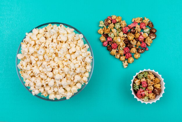 Vue de dessus du pop-corn dans des bols sur horizontal bleu