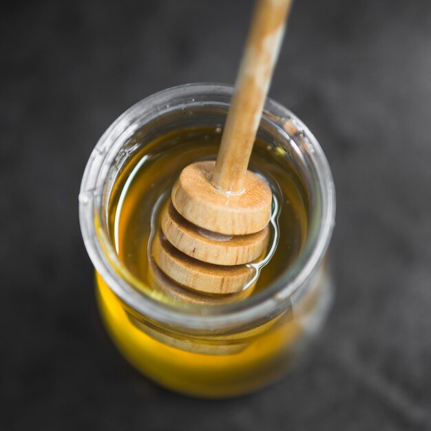 Une vue de dessus du pot de miel avec une louche en bois