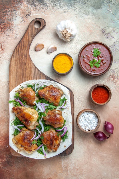 Vue de dessus du poulet ail oignon poulet aux herbes sur sauce lavash épices colorées