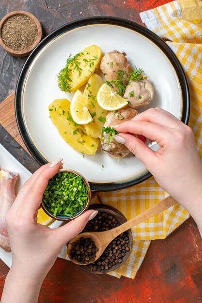 Vue de dessus du poulet bouilli avec des pommes de terre cuites obtient des verts sur fond sombre couleur des aliments repas sauce plat cuisine dîner viande